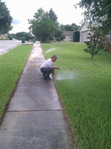 a Santa Rosa Sprinkler Repair tech aims a sprinkler head for better coverage